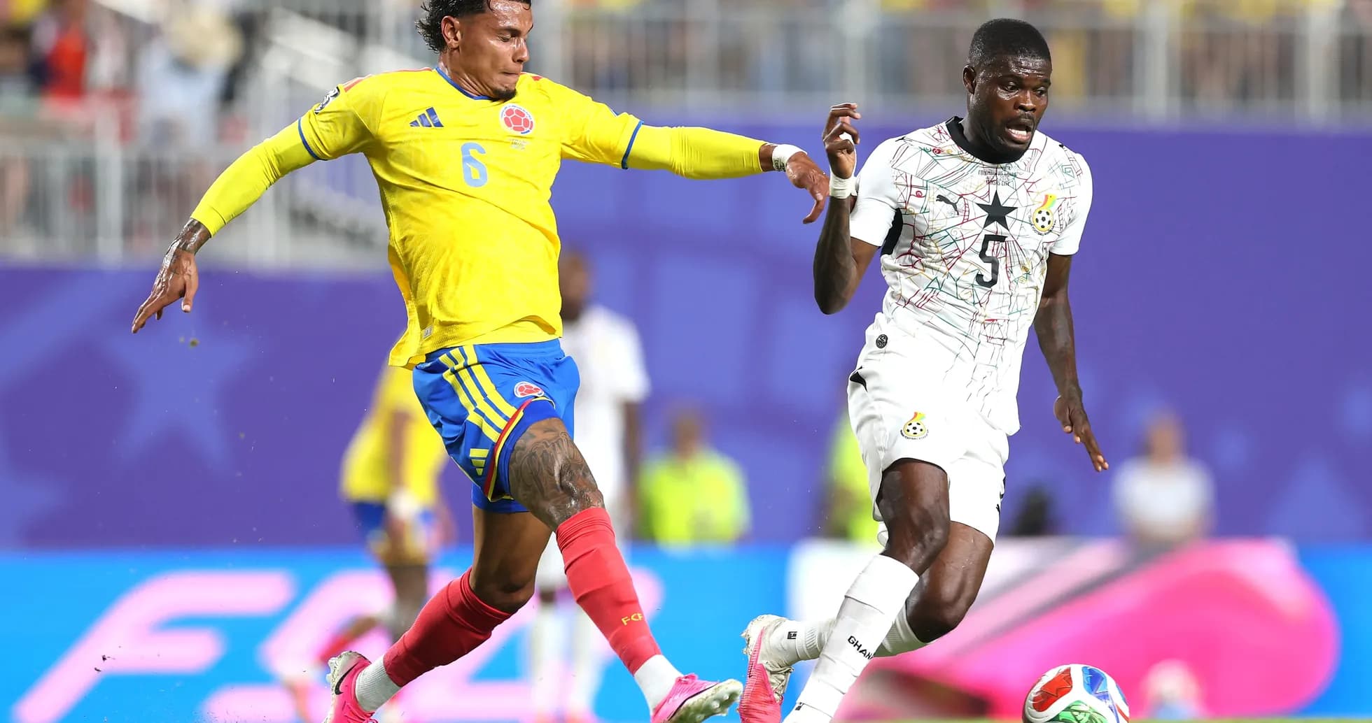Jugador colombiano persigue a rival ghanés Jugador colombiano persigue a rival ghanés