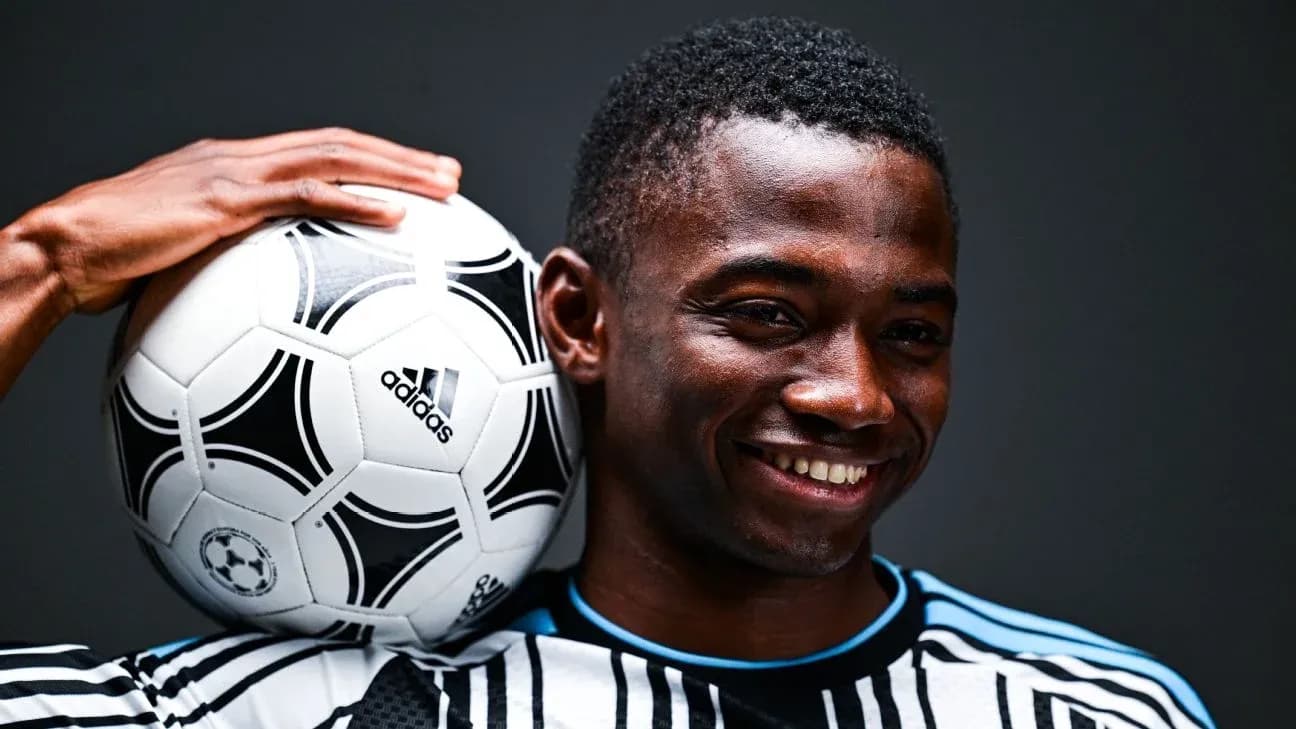 Jugador sosteniendo un balón de fútbol con sonrisa Jugador sosteniendo un balón de fútbol con sonrisa