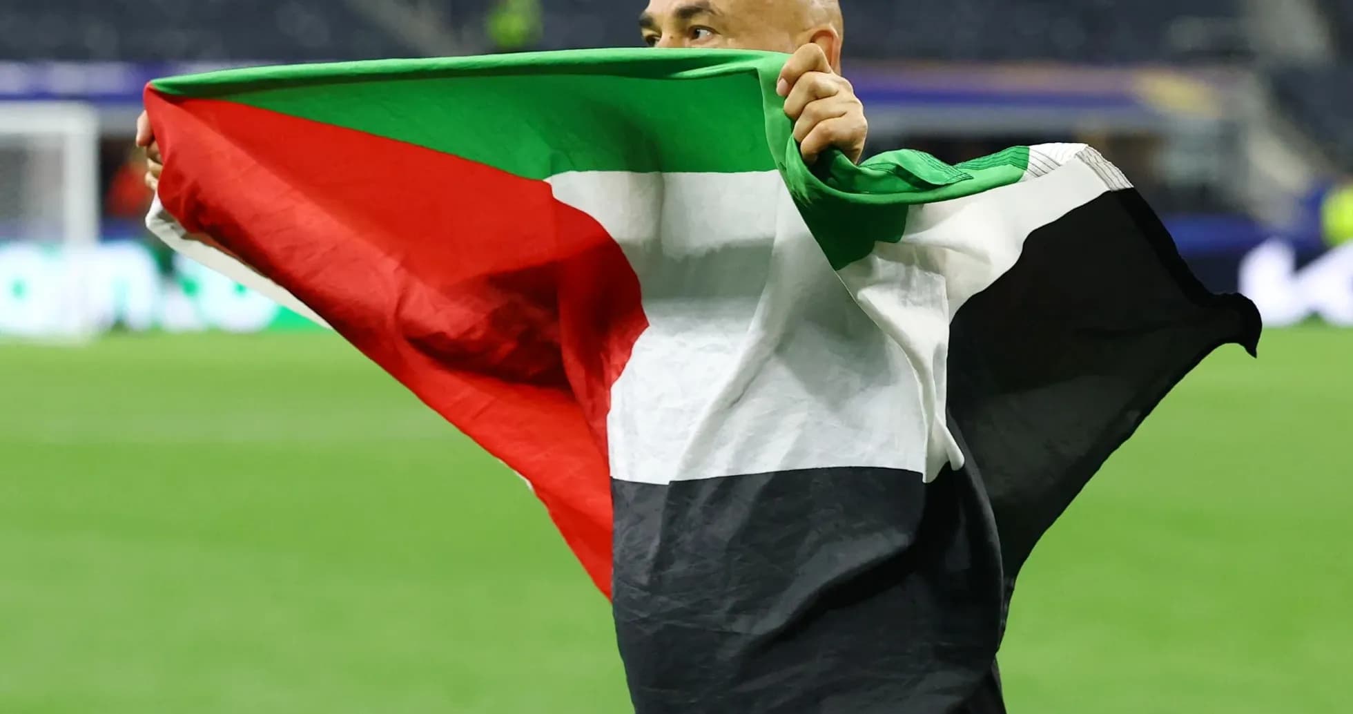 Hombre sosteniendo una bandera en el campo de fútbol Hombre sosteniendo una bandera en el campo de fútbol