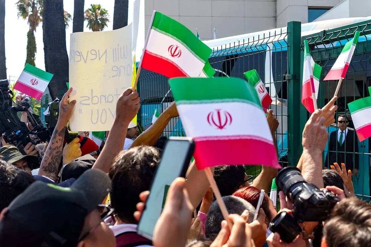 Multitud sosteniendo banderas de Irán durante protesta Multitud sosteniendo banderas de Irán durante protesta