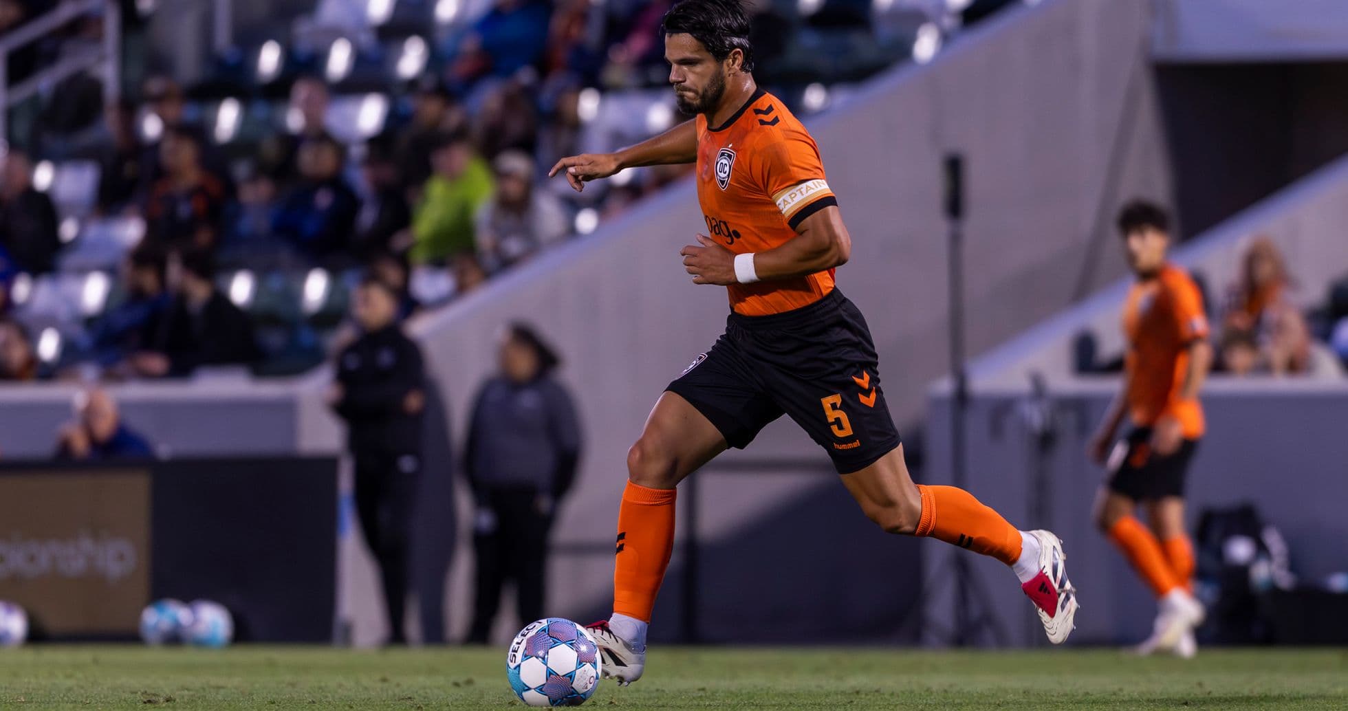 Jugador de Orange County SC corriendo con el balón Jugador de Orange County SC corriendo con el balón