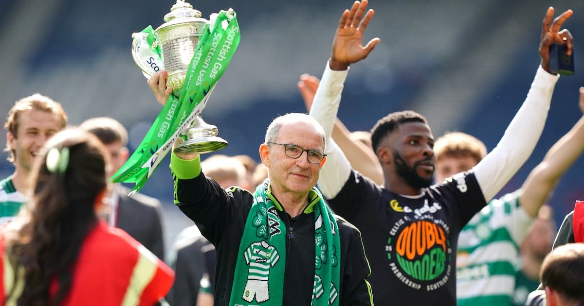 Hombre levantando trofeo con bufanda verde en celebración Hombre levantando trofeo con bufanda verde en celebración